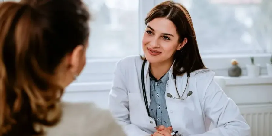 家庭 nurse practitioner smiling with patient during appointment